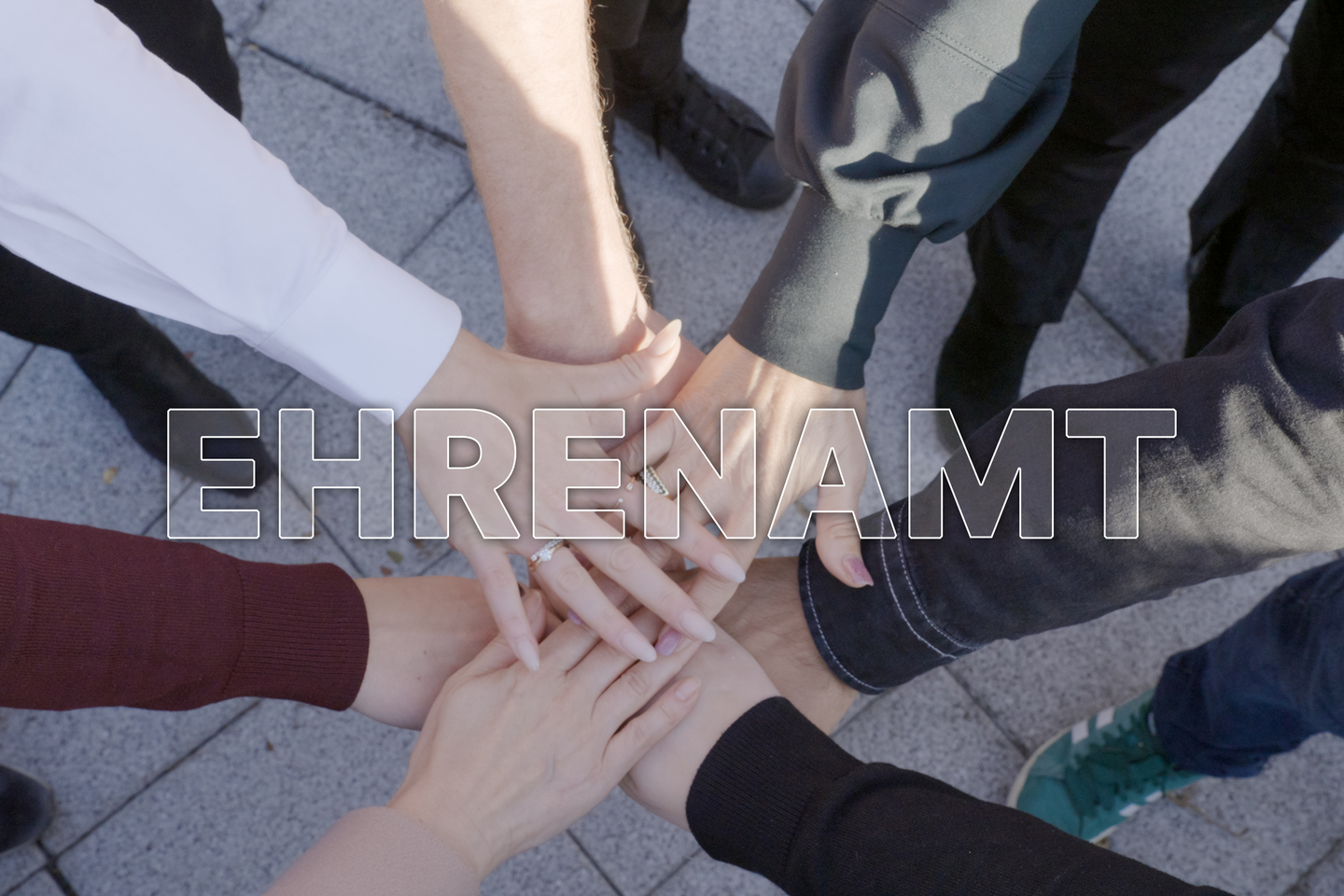 Viele Hände übereinander – Symbol für Ehrenamt und Zusammenhalt